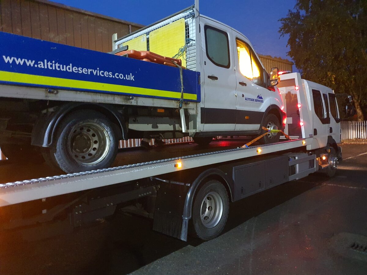 Altitude Services Ford Transit dropside van loaded on the Breakdown Man recovery truck at night for commercial van recovery.
