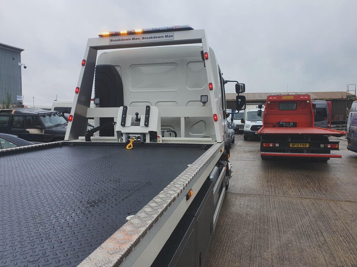 Breakdown Man recovery truck parked at a Volkswagen dealership ready for a car towing job.