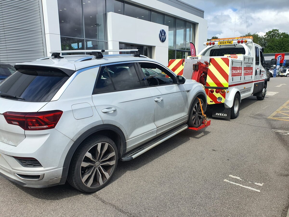 Silver Volkswagen T-Roc loaded on a Breakdown Man recovery truck outside a VW dealership in Wigan.
