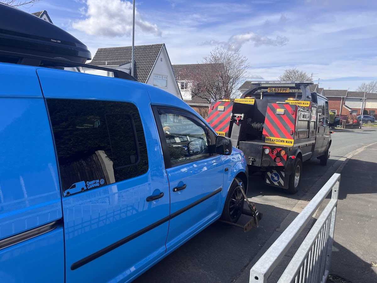 Towing a blue VW Caddy van.